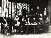 Grupa pracowników dozoru relaksuje się po pracy w ogrodzie hutniczym. Zdjęcie z przełomu XIX i XX wieku.