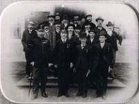 Zdjęcie grupy pracowników zarządu huty, wykonane przed gospodą hutniczą. Przełom XIX i XX wieku.